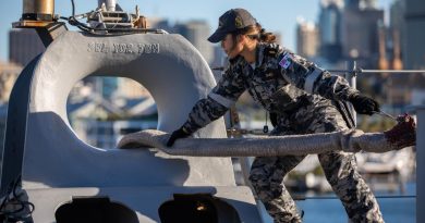 Able Seaman Boatwain Mate Linda Emelio handles lines on the quarterdeck of HMAS Canberra while departing Fleet Base East in Sydney. Photo by Petty Officer Christopher Szumlanski