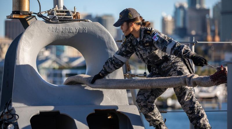 Able Seaman Boatwain Mate Linda Emelio handles lines on the quarterdeck of HMAS Canberra while departing Fleet Base East in Sydney. Photo by Petty Officer Christopher Szumlanski