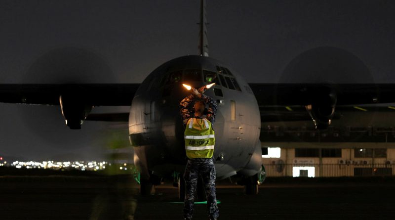 Aircraftman Sam Schmidt, from the No. 382 Squadron, marshals a C-130J from RAAF Base Richmond at the Air Movements Wing – Port Moresby. Story by Major Martin Hadley. Photo by Corporal Jonathan Geodhart.