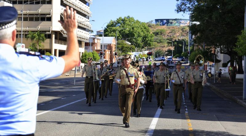 The band of the 1st Battalion, Royal Australian Regiment, led by Lieutenant Colonel Daniel Hiscock, is challenged by a Queensland policeman during the parade in Townsville. Story by Sergeant Matthew Bicker ton. Photo by Sergeant James Duquemin.