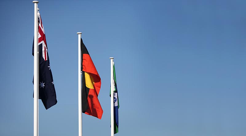 The Australian National Flag at full mast alongside the Aboriginal Flag and the Torres Strait Islander Flag at Darwin's Larrakeyah Barracks. Photo by Leading Seaman James Whittle.