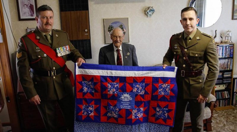 Lieutenant Kurt O’Neill and Sergeant Steven Banks, from the School of Armour, present WW2 veteran, 101-year-old Bertram (Bert) Sutton, with an Aussie Hero Quilt at his home in Numurkah, Victoria.