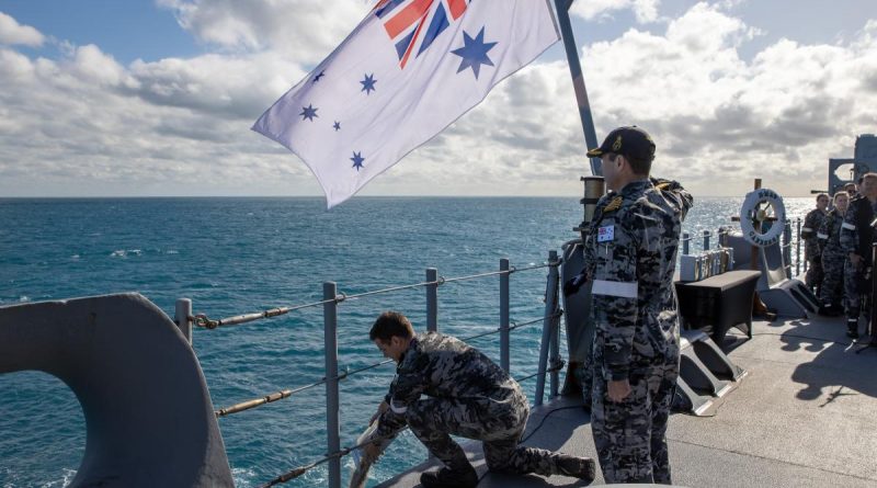 Executive Officer HMAS Canberra Commander Justin Cloney scatters the ashes of former Navy navigation officer, Captain Michael Freeman, during a committal of ashes to the sea ceremony. Story by Lieutenant Nancy Cotton. Photo by Petty Officer Christopher Szumlanski.