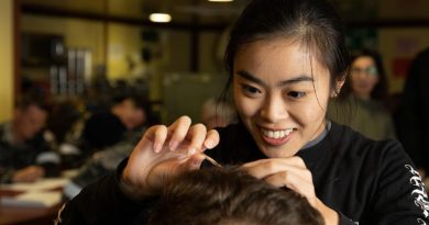 Macquarie University researcher Madison Kho takes a hair sample from a HMAS Canberra crew member to measure cortisol levels. Story by Lieutenant Nancy Cotton. Photo by Leading Seaman Matthew Lyall.