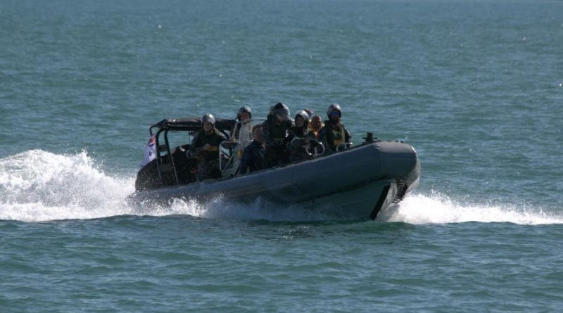 Personnel from HMAS Maryborough transport three rescued civilians in a rigid hull inflatable boat off Darwin, Northern Territory. Story by Lieutenant Max Logan.