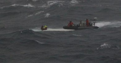 HMAS Brisbane’s rigid hulled inflatable boat crew rescues the stricken mariners from the hull of their upturned yacht off the coast of Wollongong. Photo supplied.