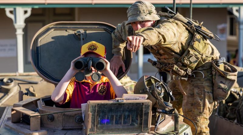 A soldier from 3rd Battalion, Royal Australian Regiment interacts with a Charters Towers local at the at the Exercise Brolga Run 2022 community open day. CAPTION: Captain Diana Jennings. Photo by Gunner Gregory Scott.