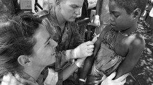 Private Mark Spearpoint from 1RAR and Corporal Kim Felmingham, medic, administer measles immunisations in the Baidoa, Somalia, 1993. Photo by WO2 Terry Dex.