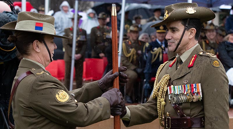 The RSM-A's pace stick is handed from incoming Chief of Army Lieutenant General Simon Stuart to incoming Regimental Sergeant Major–Army Warrant Officer Kim Felmingham during the Chief of Army handover parade at Russell Offices in Canberra on 1 July 2022. Photo by Kym Smith.