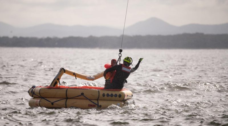 A member of Air Force's No. 2 Squadron is winched from a life raft on Nelson Bay to a search and rescue helicopter during a survival training exercise. Story by Flight Lieutenant Claire Burnet. Photo by Lieutenant Samuel Hicks.