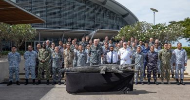 Exercise Kakadu Final Planning Conference delegates gather outside Darwin Convention Centre accompanied by the adopted exercise mascot, a 4-metre-long wooden crocodile nicknamed 'Fluffy'. Story by Lieutenant Commander Andrew Herring. Photo by Sergeant Pete Gammie.