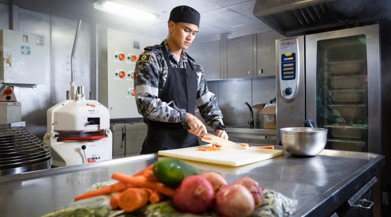 Maritime Logistics Chef Able Seaman Zachary Galit prepares vegetables in the galley of HMAS Canberra during Exercise Rim of the Pacific (RIMPAC) 2022 in the Pacific Ocean. Story and photo by Leading Seaman Matthew Lyall.