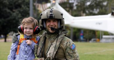 Australian Army Aircrewman Corporal Matthew Nebauer and young Olivia get ready for a flight on a Helicorp-leased Leonardo AW139 helicopter during Exercise Care Bear at James Cook University oval in Townsville. Story and photo by Captain Carolyn Barnett.