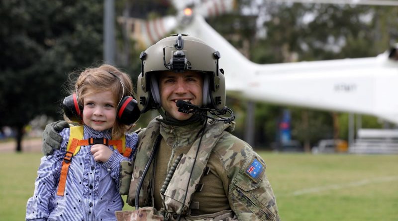 Australian Army Aircrewman Corporal Matthew Nebauer and young Olivia get ready for a flight on a Helicorp-leased Leonardo AW139 helicopter during Exercise Care Bear at James Cook University oval in Townsville. Story and photo by Captain Carolyn Barnett.