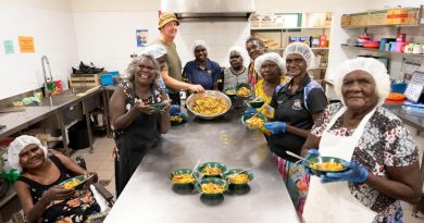 Army soldier Sergeant Nathan Judd with Gapuwiyak community members enjoying the meal they cooked during hospitality training as part of the Army Aboriginal Community Assistance Program in Gapuwiyak, Northern Territory. Story by Captain Annie Richardson. Photo by Corporal Lucas Petersen.