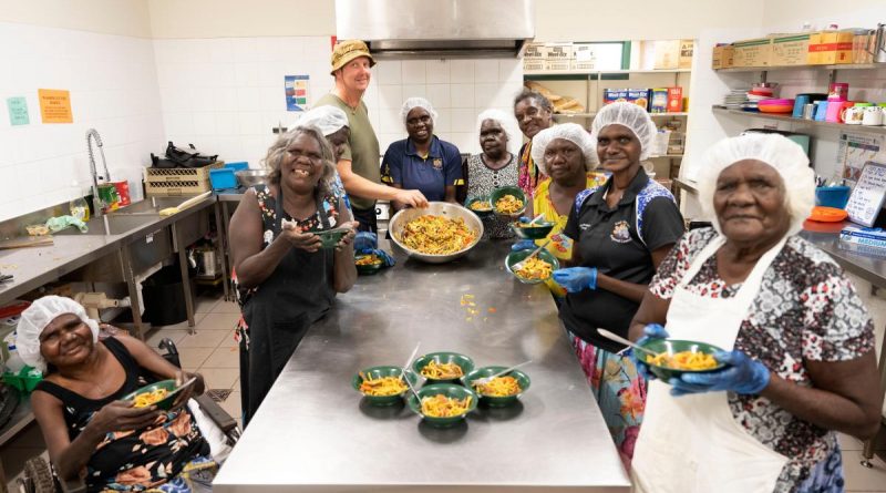 Army soldier Sergeant Nathan Judd with Gapuwiyak community members enjoying the meal they cooked during hospitality training as part of the Army Aboriginal Community Assistance Program in Gapuwiyak, Northern Territory. Story by Captain Annie Richardson. Photo by Corporal Lucas Petersen.