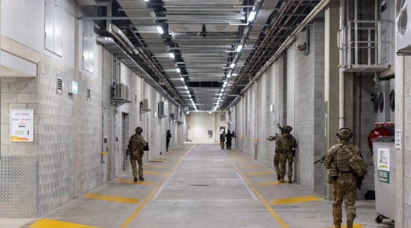 Members of the ADF and Queensland Police Service clear the lower levels of the Queensland Country Bank Stadium as part of Exercise Austral Shield 2022 in Townsville. Lieutenant Geoff Long. Photo by Corporal Jonathan Goedhart.