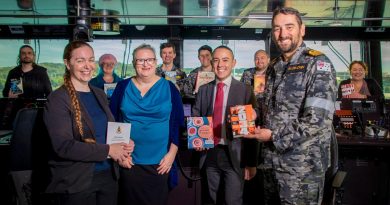 Library Manager Kym Andrews, left, Librarian Penelope Sherrell, Assistant Director Defence Archives and Services Centre Michael Chow and Commander Steve McCracken with donated library books on the bridge of HMAS Stalwart. Story by Lieutenant Gary McHugh. Photo by Petty Officer Richard Cord.