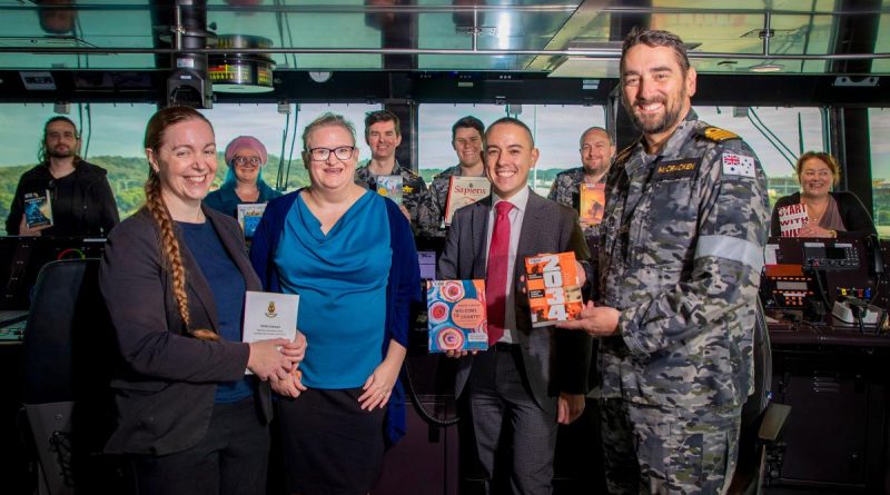 Library Manager Kym Andrews, left, Librarian Penelope Sherrell, Assistant Director Defence Archives and Services Centre Michael Chow and Commander Steve McCracken with donated library books on the bridge of HMAS Stalwart. Story by Lieutenant Gary McHugh. Photo by Petty Officer Richard Cord.