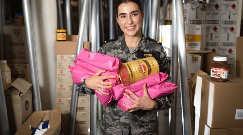 Maritime Logistics Officer Sub-Lieutenant Amelia Ross holds an assortment of coffee products in the dry store of HMAS Canberra during Exercise Rim of the Pacific (RIMPAC) 2022 in the Pacific Ocean. Story by Lieutenant Nancy Cotton. Photo by Leading Seaman Matthew Lyall.