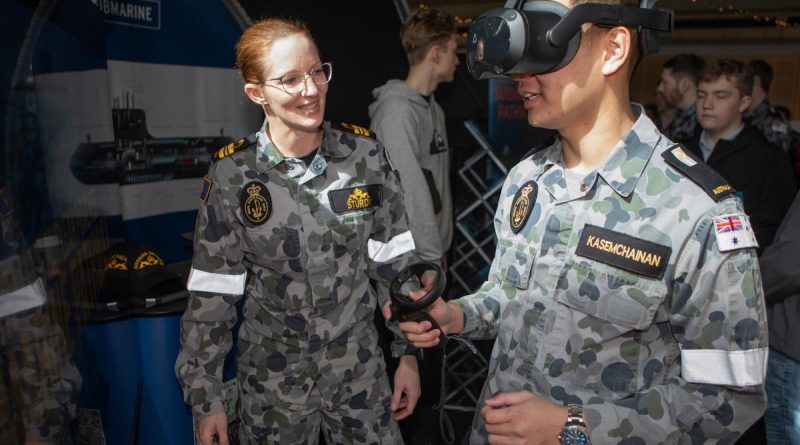 Lieutenant Commander Siobhan Sturdy guides Midshipman Kane Kasemchainan through a virtual training demonstrator at the Australian Defence Force Academy open day. Story by Lieutenant Yvette Goldberg. Photo by Petty Officer Bradley Darvill.
