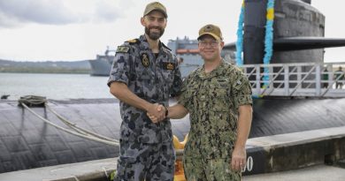 Navy submariner Lieutenant Commander Daniel McCall, left, and US Navy Submarine Squadron 15 Commanding Officer Captain Bret Grabbe stand in front of USS Key West, alongside US Naval Base Guam. Story by Lieutenant Sarah Rohweder. Photo by Mass Communication Specialist 3rd Class Naomi Johnson.