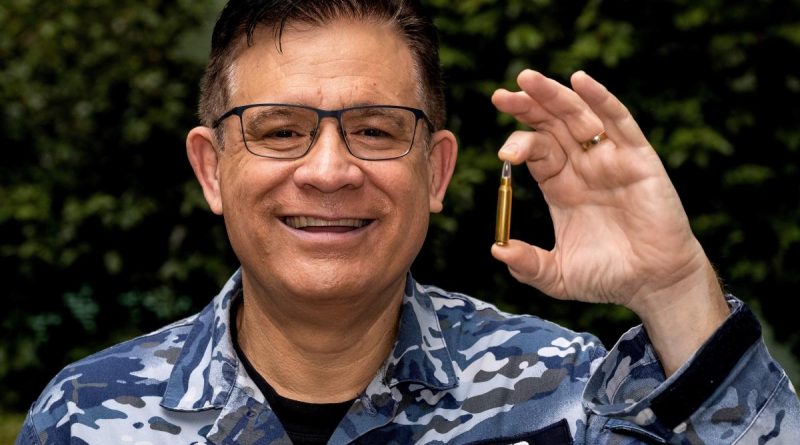 Flight Lieutenant Nick Fraser with his invention, the Audible Feedback Training Round. Story by Evana Ho. Photo by Flight Sergeant Kev Berriman..