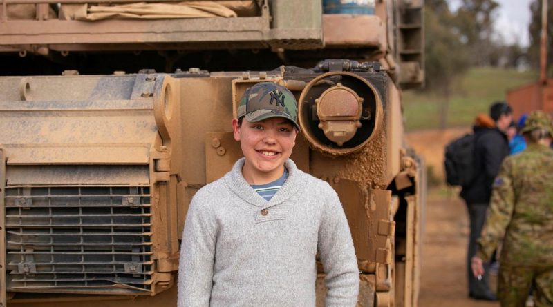 Dash Gurung stands in front of an Australian Army M113 armoured personnel carrier after the firepower demonstration at Puckapunyal. Story by Major Carrie Robards. Photo by Lance Corporal Katy Manning.