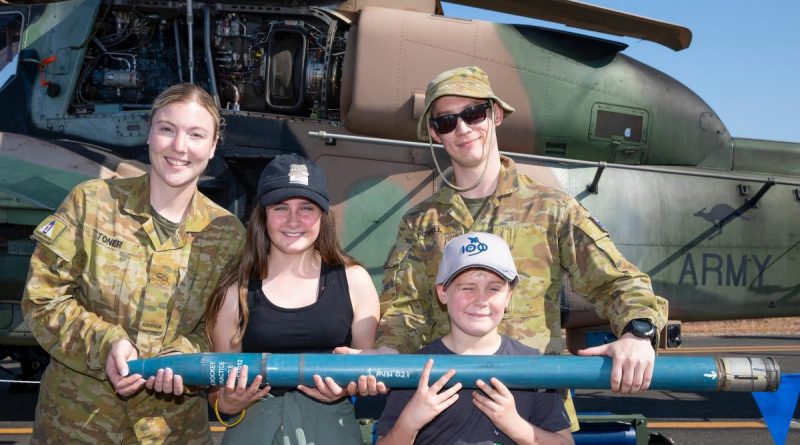 Craftsman Amber Toner, left, and Craftsman Cameron Powell, from 1st Aviation Regiment, with Emily and Oliver Taaffe and a 70mm rocket from the Tiger helicopter during the Exercise Pitch Black open day at RAAF Base Darwin. Story by Flight Lieutenant Jessica Winnall. Photo by Corporal Kylie Gibson.