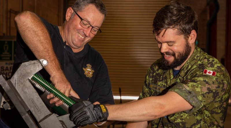 RAAF ground support equipment technician Corporal James Harding, left, and Royal Canadian Air Force aircraft arrestor systems technician Corporal Evan Barbeau maintain a BAK arrestor arm. Flight Lieutenant Jessica Winnall. Photo by Leading Aircraftwoman Annika Smit.