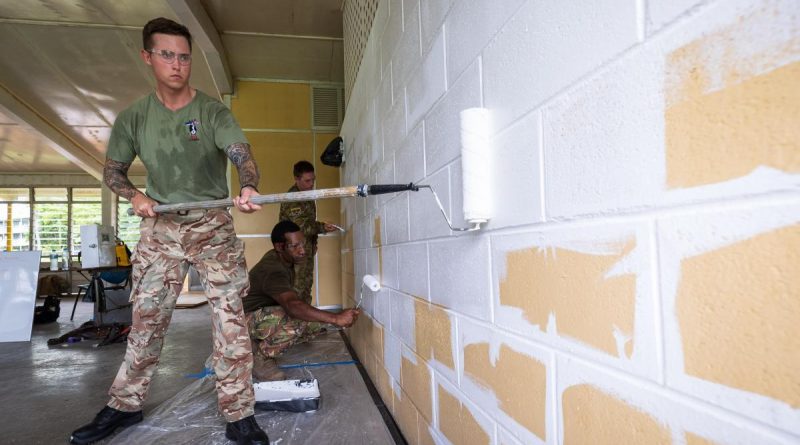 British Army Lance Corporal Shane Bundy, left, PNGDF Lance Corporal Clement Nibabe, kneeling, and Australian Army Sapper Anthony Toigo, paint the guardhouse walls during Exercise Puk Puk at Goldie River Training Depot. Story by Major Jesse Robilliard. Photo by Sergeant Nunu Campos.