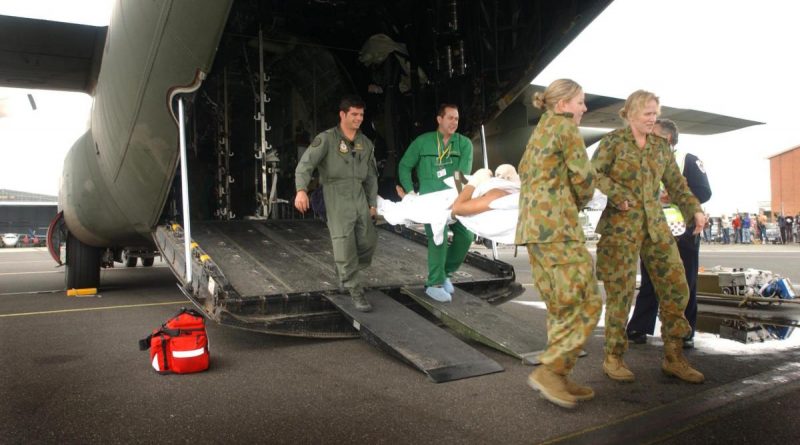 Squadron Leader Steve Cook, back left, a paramedic, Leading Aircraftwoman Hayley Edwards, front left, and Flying Officer (now Wing Commander) Kim Davey carry a Bali bombing victim from a C-130 Hercules. Story by Flight Lieutenant Suellen Heath and Corporal Jacob Joseph. Photo by Sergeant Troy Rodgers.