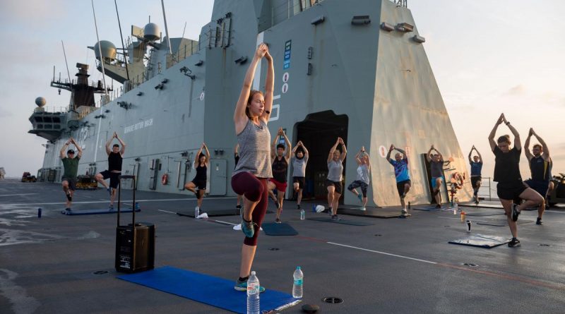 Army Physiotherapist Lieutenant Nicola Hribar leads a sunrise yoga class for members of ship’s company and embarked forces on the flight deck of HMAS Canberra during AUSINDEX 2019. Story by Sergeant Matthew Bickerton. Photo by Leading Seaman Steven Thomson.