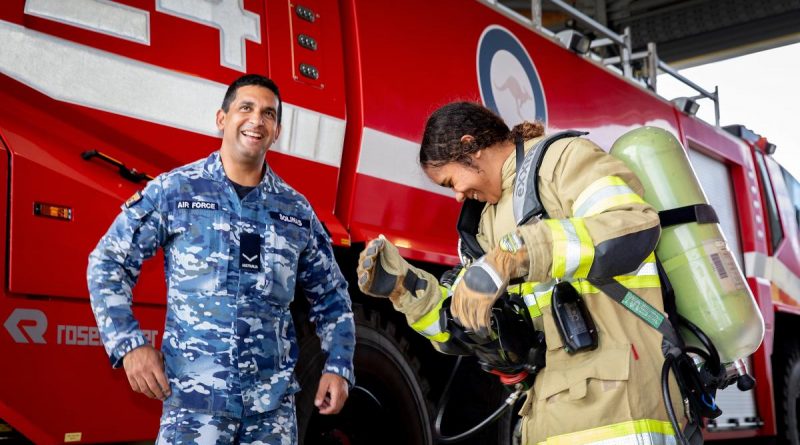 Air Force Indigenous Youth program participant Tallira Hopkins tries on the firefighter uniform with firefighter Leading Aircraftman Ray Solinas at RAAF Base Amberley, Queensland. Story by Flight Lieutenant Suellen Heath. Photo by Leading Aircraftwoman Kate Czerny.