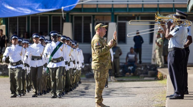 WO1 Mick Beeton, from the 1st Field Regiment Band, leads the Solomon Islands Police Force band during a march-out parade for new recruits in Honiara. Story by Lieutenant Geoff Long. Photo by Corporal Jonathan Goedhart.