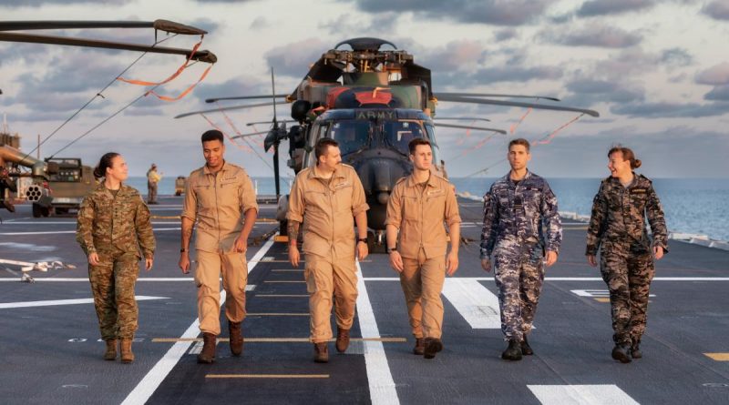 Australian Defence Force and German Navy members walk along the flight deck of HMAS Adelaide during Indo-Pacific Endeavour 2022. Story by Lieutenant Emma Anderson. Photo by Leading Seaman Sittichai Sakonpoonpol.