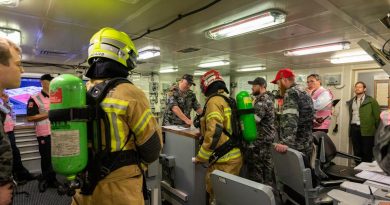 HMAS Brisbane crew, Fire and Rescue NSW and exercise observers gather in the Damage Control Centre on board Brisbane during Exercise Vulcan Phoenix at Fleet Base East, Sydney. Story by Lieutenant Nancy Cotton. Photo by Able Seaman Benjamin Ricketts.