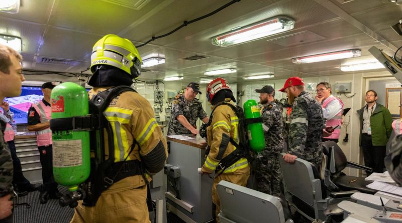 HMAS Brisbane crew, Fire and Rescue NSW and exercise observers gather in the Damage Control Centre on board Brisbane during Exercise Vulcan Phoenix at Fleet Base East, Sydney. Story by Lieutenant Nancy Cotton. Photo by Able Seaman Benjamin Ricketts.