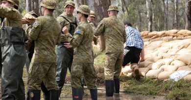 Private Jeremy Ryan, centre, of 8th/7th Royal Victorian Regiment, assists the community of Barmah, Victoria, with sandbagging as part of Operation Flood Assist 22-2. Story by Flight Lieutenant Vernon Pather. Photo by Corporal Jonathan Goedhart.