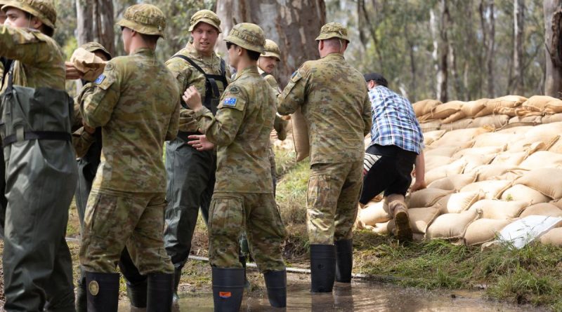 Private Jeremy Ryan, centre, of 8th/7th Royal Victorian Regiment, assists the community of Barmah, Victoria, with sandbagging as part of Operation Flood Assist 22-2. Story by Flight Lieutenant Vernon Pather. Photo by Corporal Jonathan Goedhart.