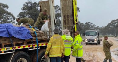 Soldiers from the 2nd/14th Light Horse Regiment (Queensland Mounted Infantry) help the NSW Rural Fire Service to unload sand bags near Deniliquin, NSW, as part of Operation Flood Assist 22-2. Photo supplied.