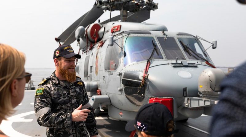 Flight Commander Lieutenant Commander Thomas Craig talks with guests from the Australian Embassy in Manila, Philippines, during a tour of HMAS Hobart while berthed in Manila Bay. Story by Captain Zoe Griffyn. Photo by Leading Seaman Daniel Goodman.