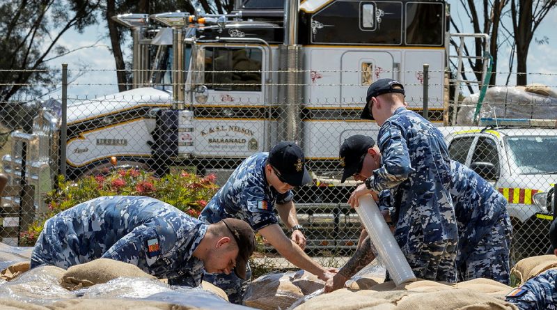 Air Force personnel wrap sandbag pallets for transportation at the New South Wales State Emergency Service depot in Forbes, during Operation Flood Assist. Story by Captain Zoe Griffyn. Photo by Corporal David Cotton.
