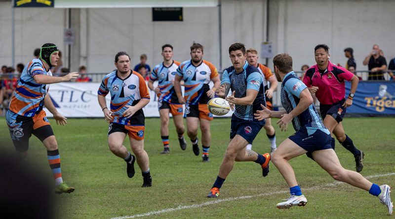 Craftsman Mathew Kelly, passes the ball during the 73rd Singapore Cricket Club International Rugby Sevens Tournament. Story by Lieutenant Amy Johnson. Photo by Leading Seaman Nadav Harel.