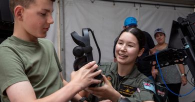 Pilot Officer Maylee Neary hands over the virtual reality headset to Lachlan at the Wings Over Illawarra Air Show. Story by Flight Lieutenant Nicholas O’Connor. Photo by Leading Aircraftman Chris Tsakisiris.