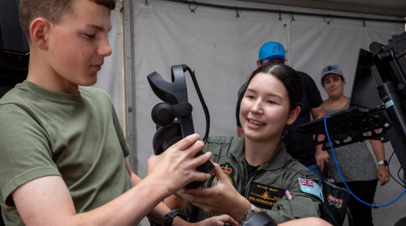 Pilot Officer Maylee Neary hands over the virtual reality headset to Lachlan at the Wings Over Illawarra Air Show. Story by Flight Lieutenant Nicholas O’Connor. Photo by Leading Aircraftman Chris Tsakisiris.