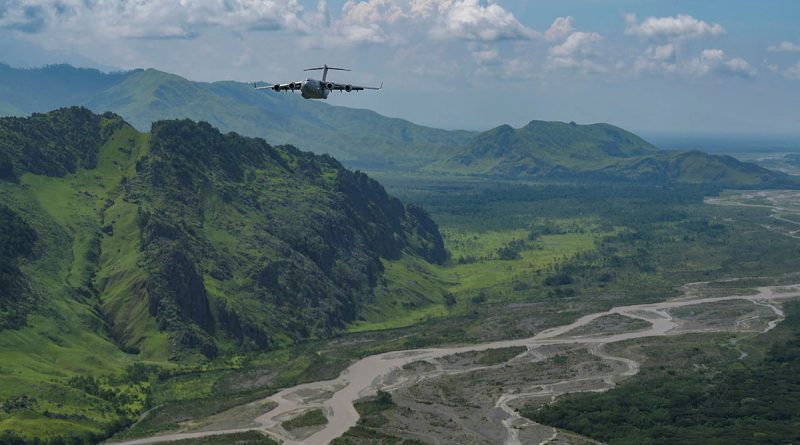 A RAAF C-17 Globemaster III flies in a 2-ship formation with a US Air Force C-17 over Papua New Guinea. Story by By Flight Lieutenant Tanya Carter. Photo by Staff Sergeant Alan Ricker.