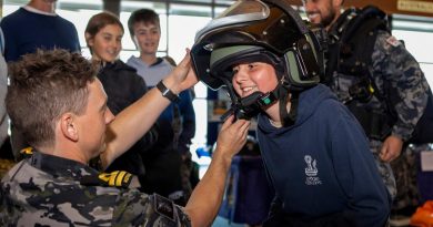 Lieutenant Joel Woods from Clearance Diver Team Four helps Dodhi with a bomb suit helmet during his tour at the Fremantle Ports Maritime Day in Western Australia. Photo by Leading Seaman Ernesto Sanchez.