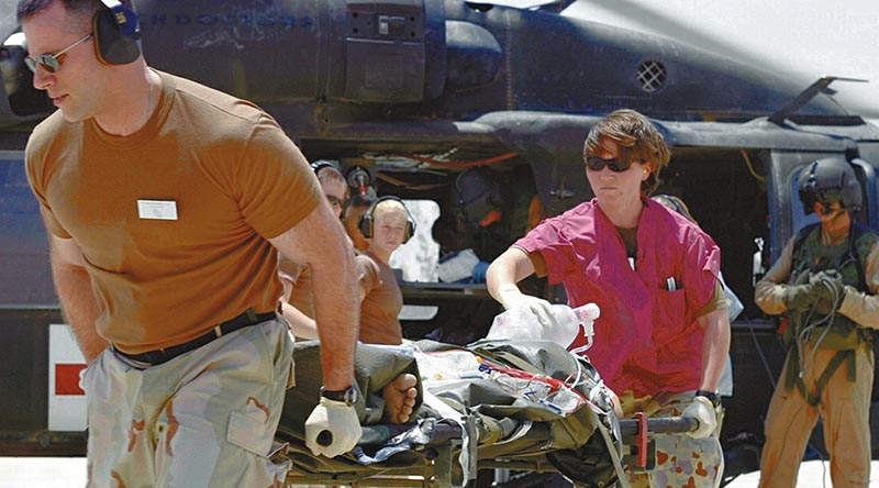 Australian Army Sergeant Tarese Heath (operating ventilator) and US colleagues transfer a wounded patient from a medical evacuation helicopter to the Emergency Department of the Air Force Theater Hospital at Balad, Iraq. Photo by Major Patricia Anderson, US Army.