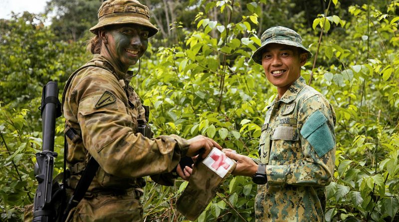 Private Kirsty Joyce, from Rifle Company Butterworth Rotation 137, swaps patches with a Royal Brunei Land Force Medic from the 3rd Battalion. Story by Captain Diana Jennings. Photos by Bombardier Guy Sadler.